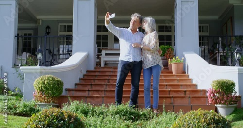 Senior couple taking selfie in homeyard 4k photo