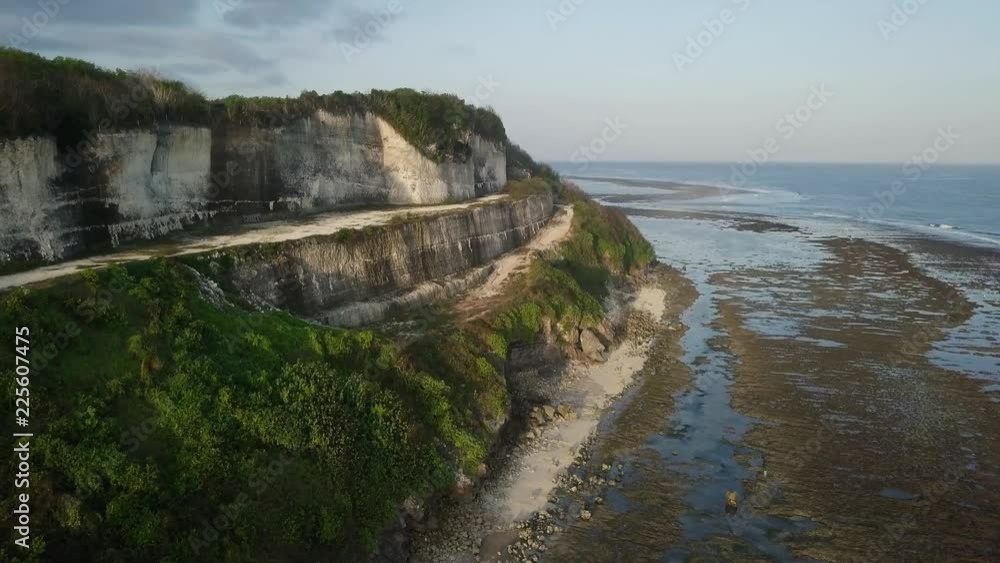 Aerial view of sandy beach with coastal cliffs and coral reefs Aerial view of sandy beach with coastal cliffs and coral reefs