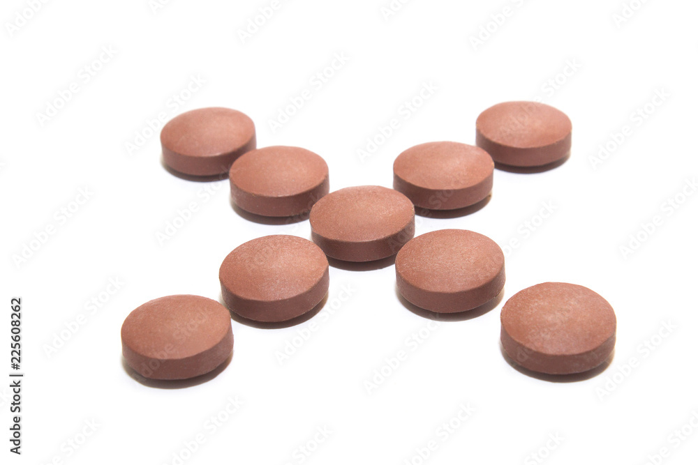 Brown pills in the form of a cross on a white background. Side view Brown pills in the form of a cross on a white background. Side view