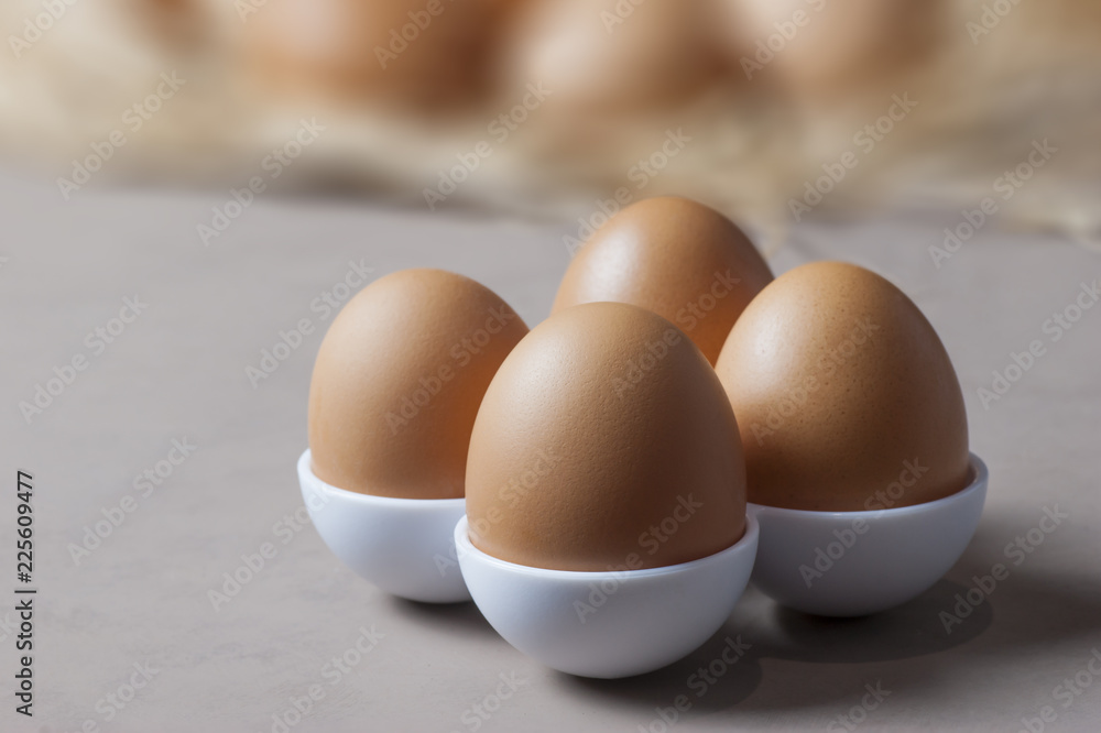Brown or yellow Fresh farm eggs on quaternary eggcup, eggs background
Brown or yellow Fresh farm eggs on quaternary eggcup, eggs background