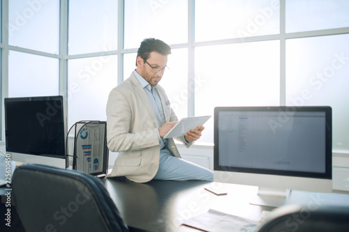 businessman with digital tablet sitting on office Desk.