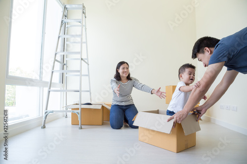 Happy Asian family with cardboard boxes in new house at moving day, Real estate and home concept