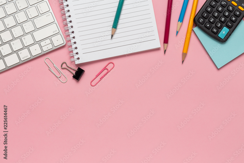 Top view office desk with smartphone, computer and office supplies on the desk pink background Top view office desk with smartphone, computer and office supplies on the desk pink background