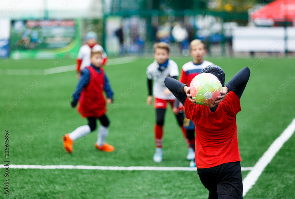  football teams - boys in red, blue, white uniform play soccer on the green field. boys dribbling. dribbling skills. Team game, training, active lifestyle, hobby, sport for kids concept