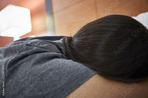 Side view of a person sleeping on a bed with shallow depth of field