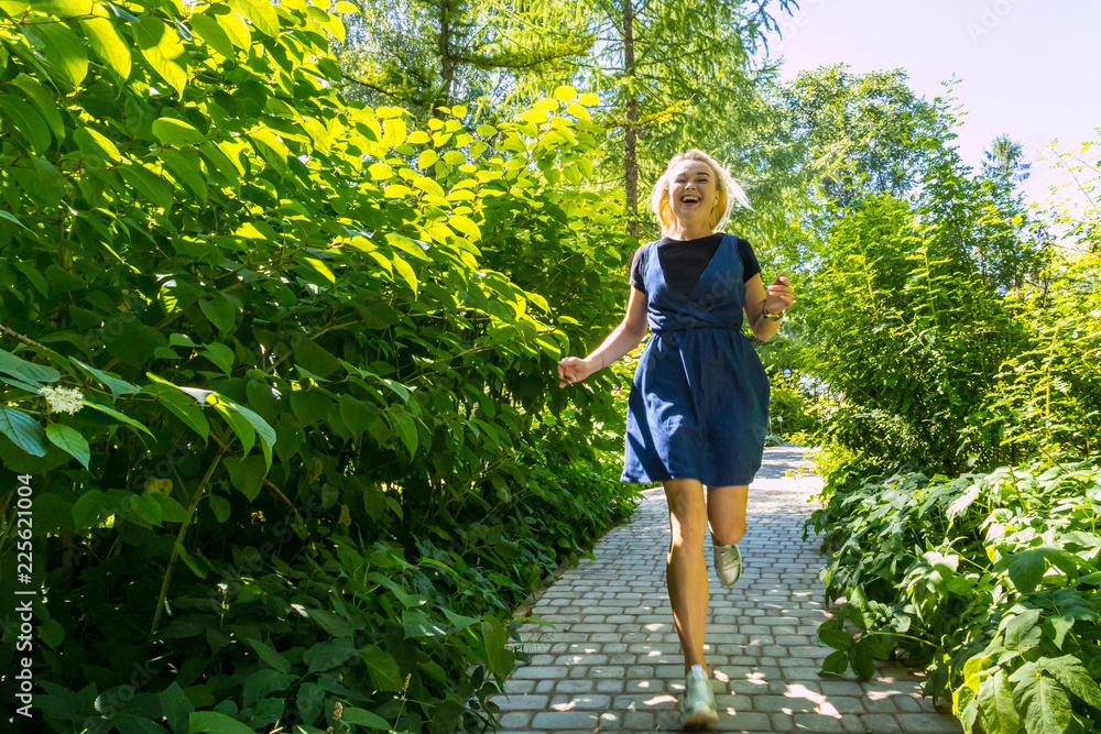 Beautiful blonde in the park. Young pretty caucasian woman walking in a summer sunny day Beautiful blonde in the park. Young pretty caucasian woman walking in a summer sunny day