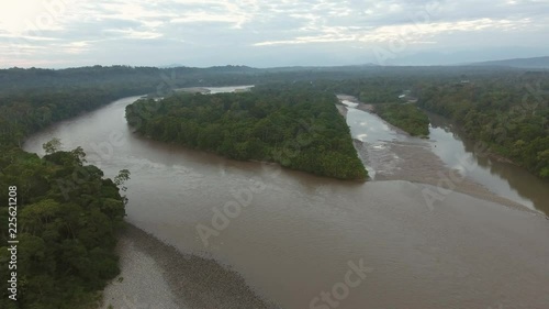 Static aerial view of a the upper Rio Napo at dawn in the Ecuadorian Amazon, looking westwards, upstream over the rainforest with  a forested island. 