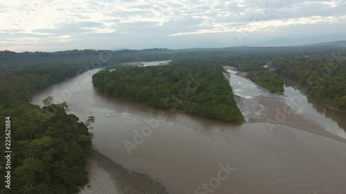 Rising high over the upper Rio Napo at dawn in the Ecuadorian Amazon, looking westwards, upstream over the rainforest. The Andes mountains are faintly visible in upper right. 