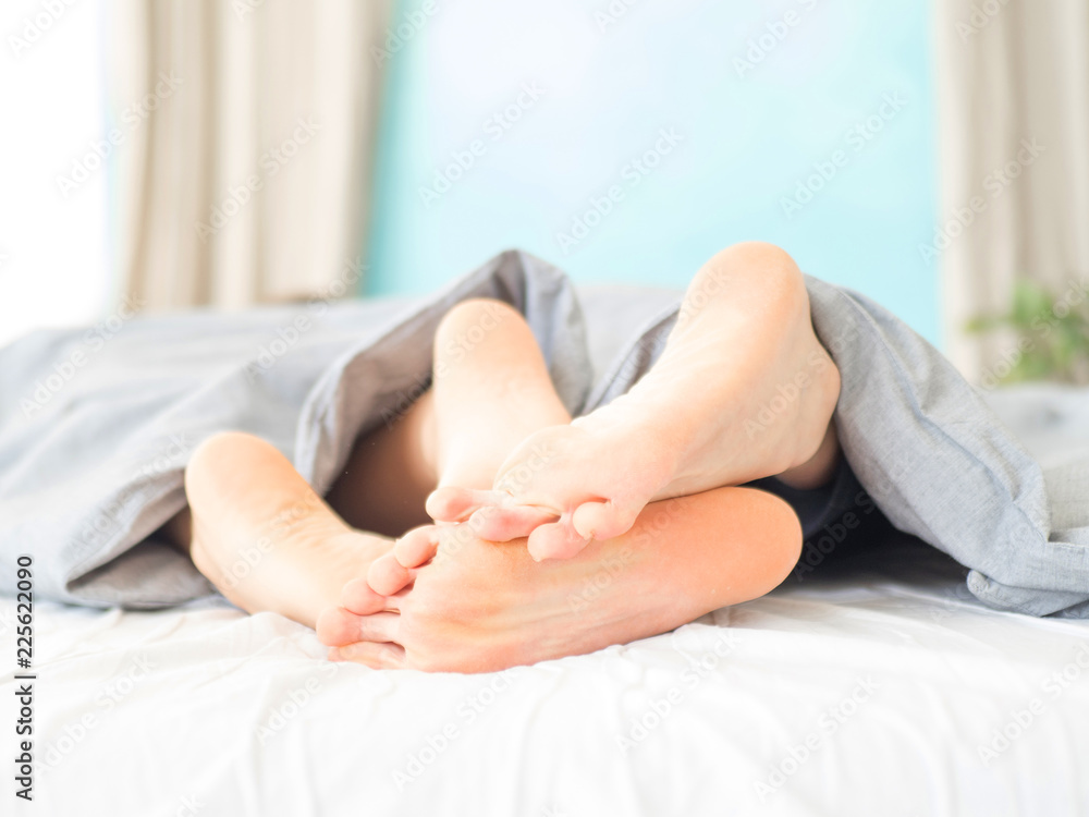 Close up view of a feet of a couple. Morning. Sensual awakening Close up view of a feet of a couple. Morning. Sensual awakening