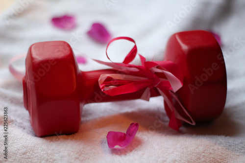 Gift-wrapped dumbbell with rose petals © Jenny