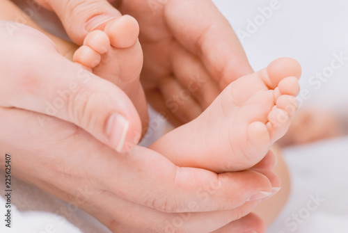 Close-up of mother hands holding tiny baby feet © Vasilev Evgenii