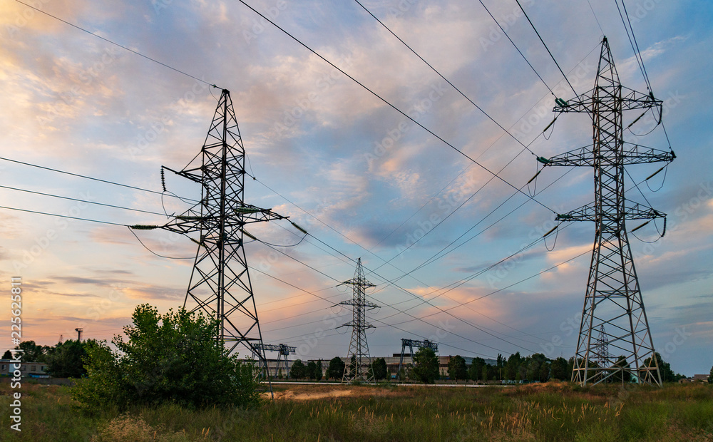 high-voltage power lines at sunset. electricity distribution station .