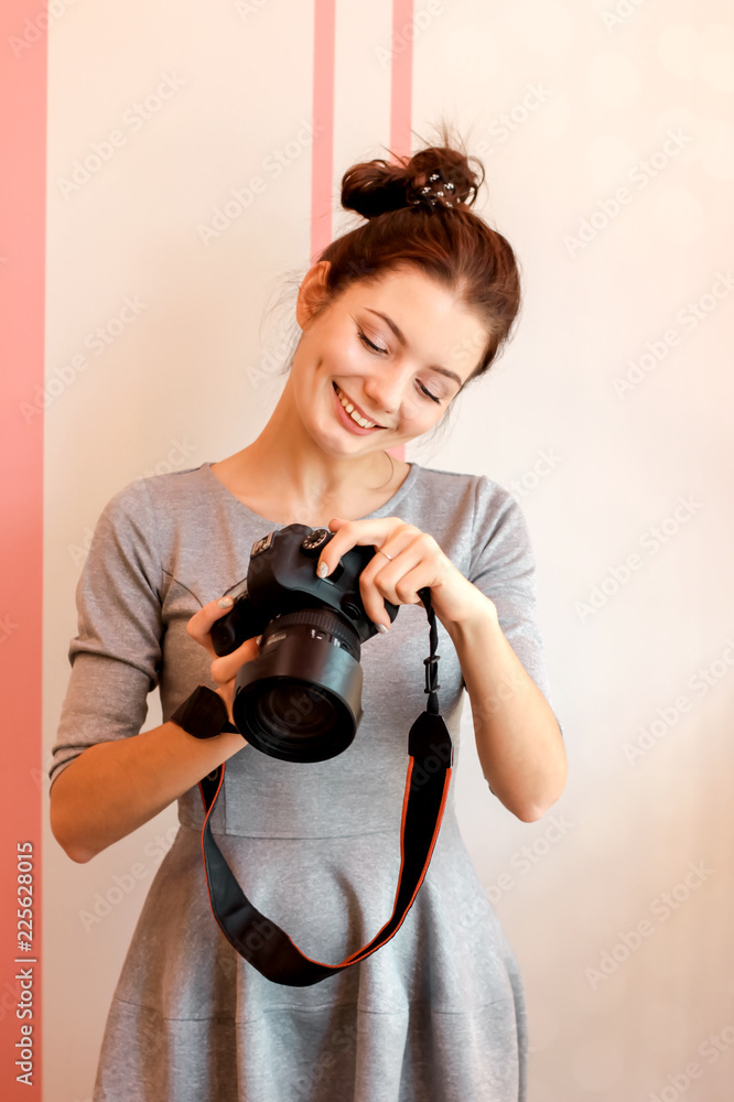 Fototapeta premium Portrait of young woman photographer smiling and holding her cam