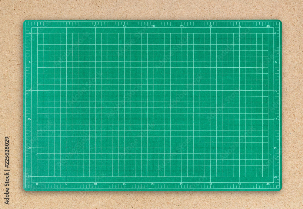 Green cutting mat on brown paper background. Green cutting mat on brown paper background.