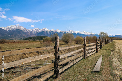 Wooden fence in field on the background of the mountain Sayan