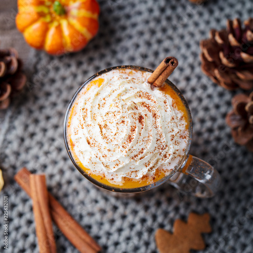 Pumpkin latte with spices and whipped cream. Grey background. Close up. Top view.