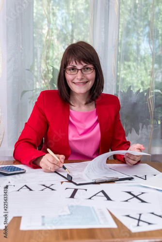 Smiling woman filling 1040 tax form in office