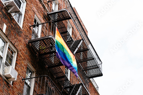 Gay rainbow flag waving on balcony in New York