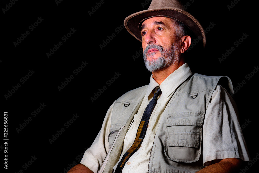 Adult adventurous man with hat and tie on black background Adult adventurous man with hat and tie on black background