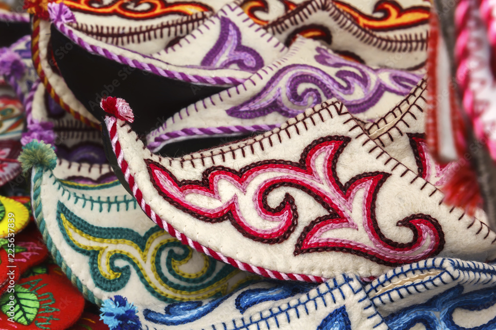 Traditional Asian shoes made of multicolored felt with embroidered colored thread of national ornament. Close-up