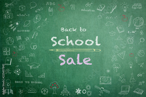 Back to school sale advertisement on school teacher’s green chalkboard background with copy space encircled by freehand students’ doodle for education announcement