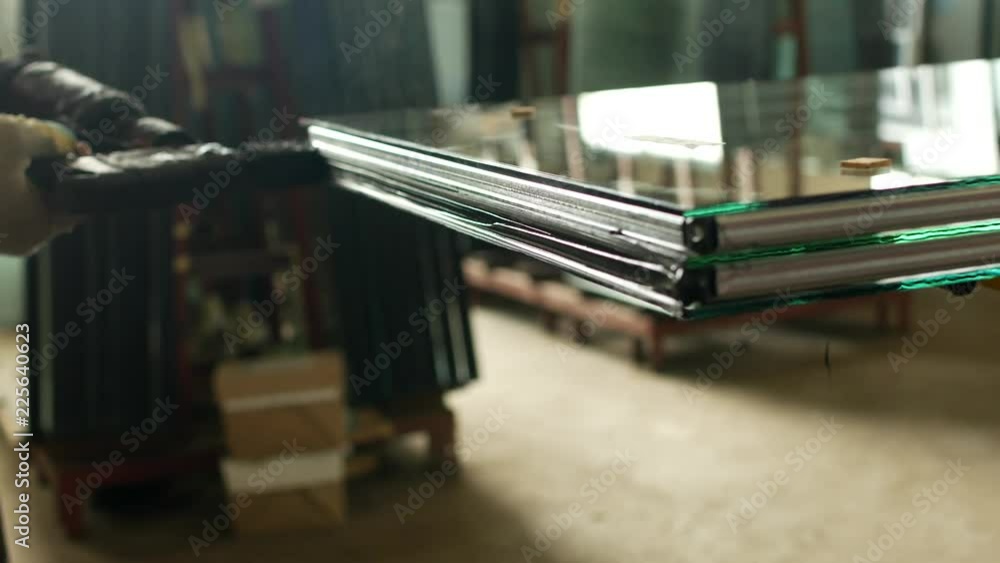 Production and manufacturing of pvc windows, the working specialist glues the glass of the double-glazed window for further assembly of the pvc window, close-up, tightness Production and manufacturing of pvc windows, the working specialist glues the glass of the double-glazed window for further assembly of the pvc window, close-up, tightness