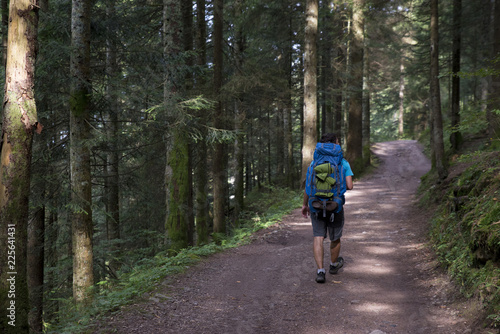 Man walking through a forest with his trekking backpack