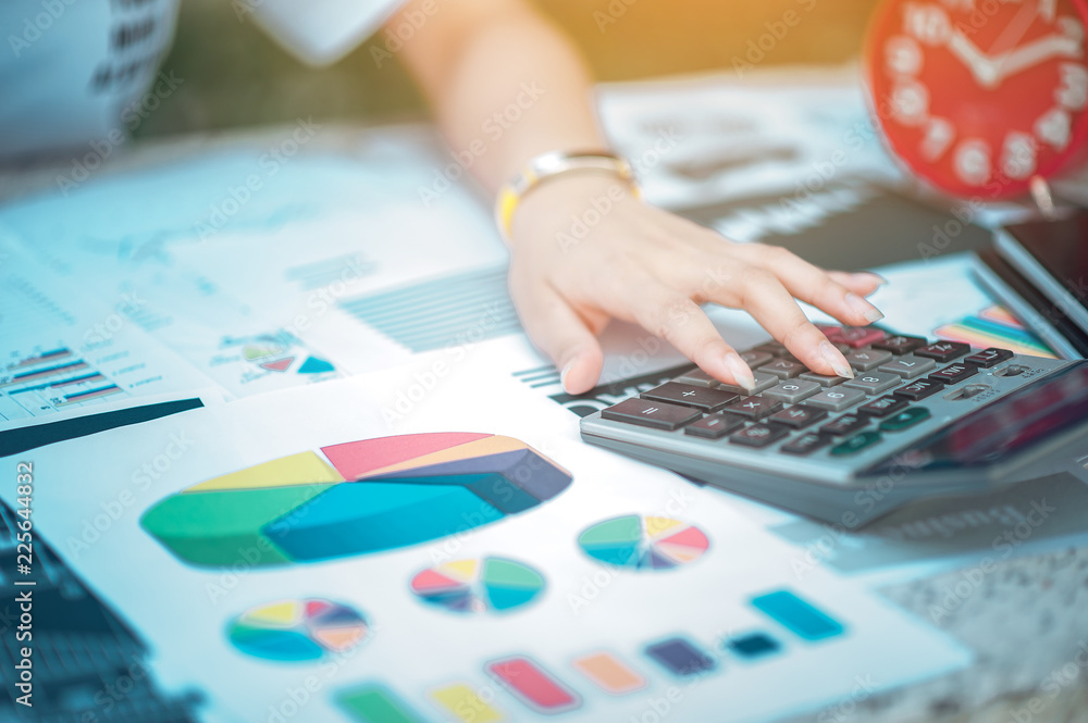 Woman sitting at desk and working at hand of book and financial documents close up