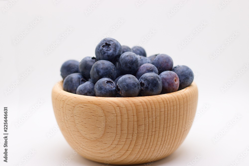 Side view of wooden bowl full of blueberries isolated on white background Side view of wooden bowl full of blueberries isolated on white background