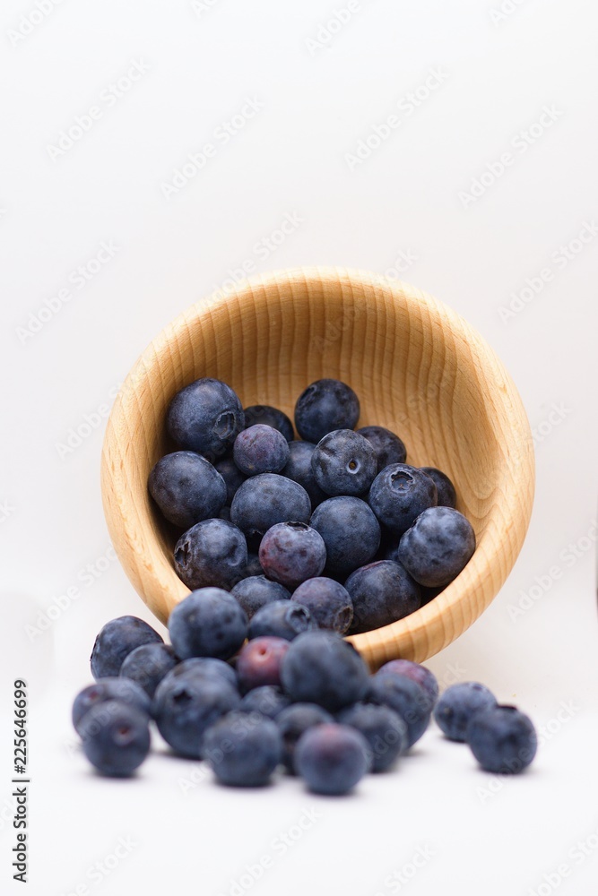 Overturned wooden bowl of fresh blueberries isolated on white background Overturned wooden bowl of fresh blueberries isolated on white background