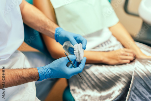 Dentist examine female patient with braces in denal office.