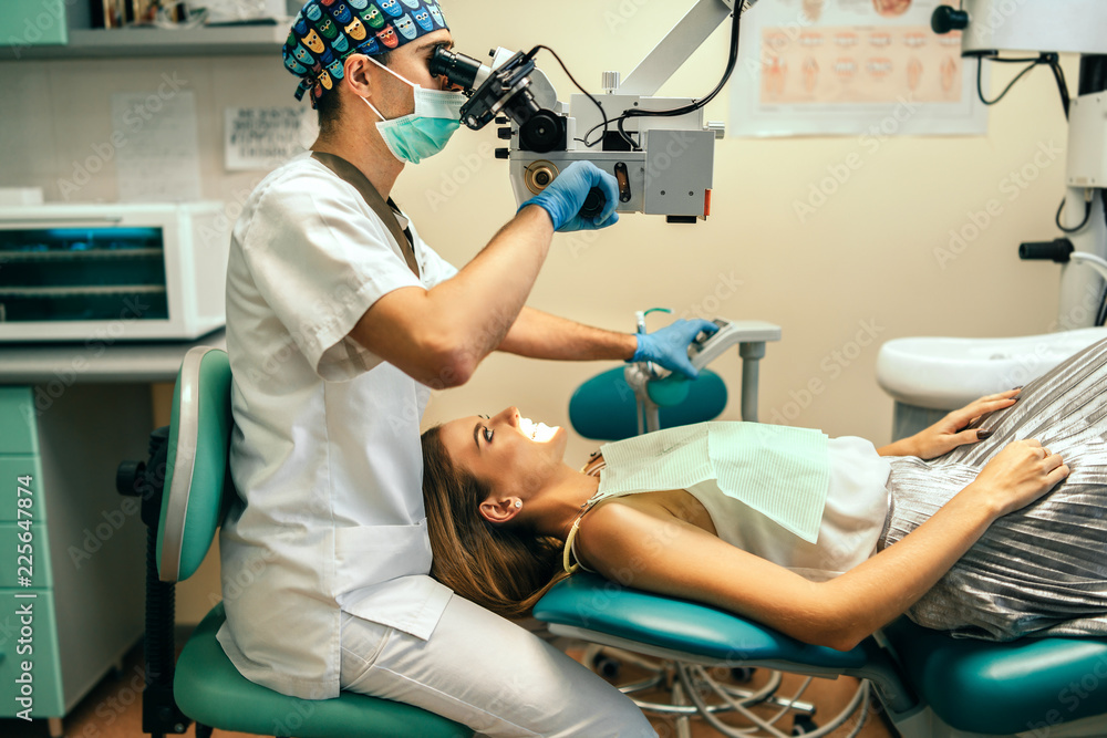 Dentist examine oral cavity of female patient with microscope. Stock ...