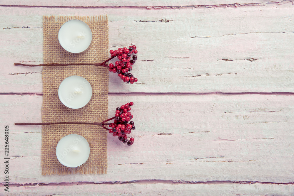 Two branches with red berries on a wooden pink table as a background for the holiday Two branches with red berries on a wooden pink table as a background for the holiday