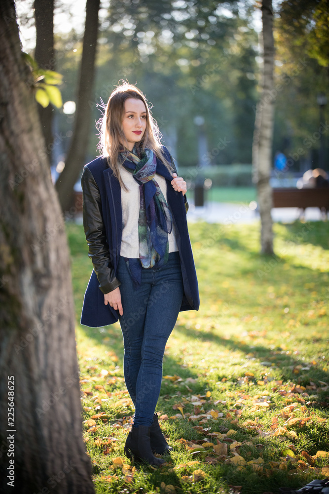 Beautiful girl with red lipstick standing in the park. Beautiful girl with red lipstick standing in the park.