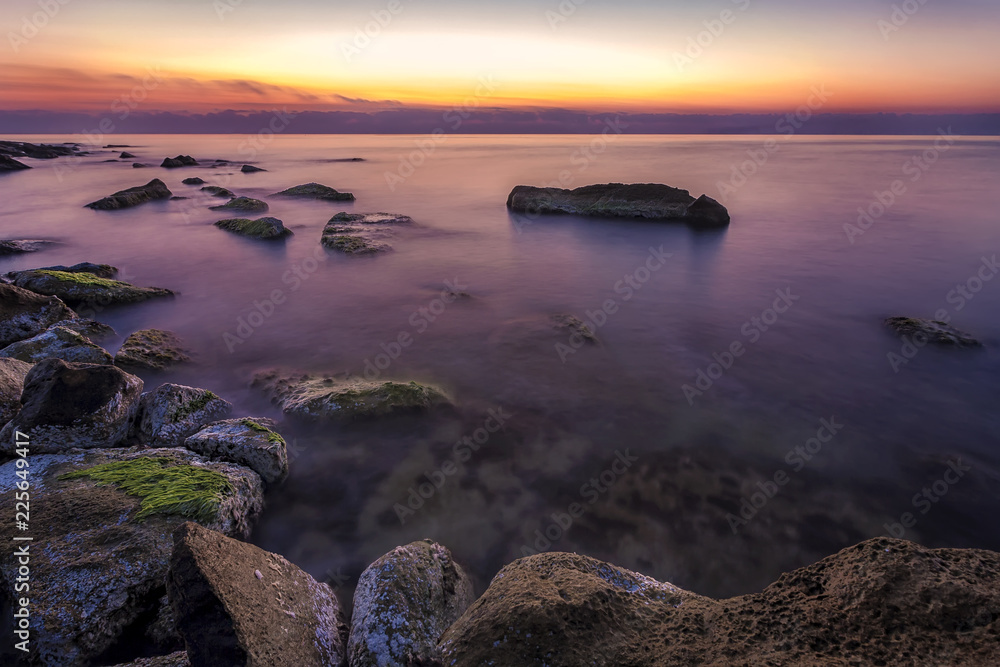 Naklejka premium colorful and tranquility rocky coast before sunrise.