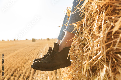 Close up of men's feet in shoes on a haystack