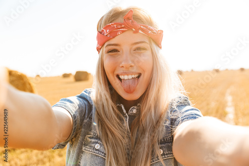 Beautiful young blonde girl in headband at the wheat field