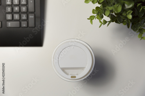 Cup of coffee in office next to computter. Working late concept photo