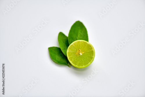 Lime fruit sliced and placed on white table.