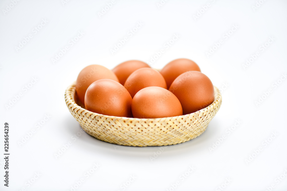 Brown eggs in the basket on a white background.