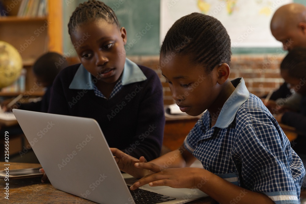 Schoolkids using laptop in classroom Schoolkids using laptop in classroom