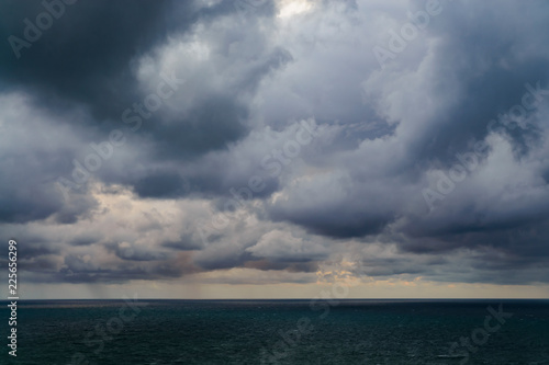 Rain clouds tightened the whole sky above the sea at sunset