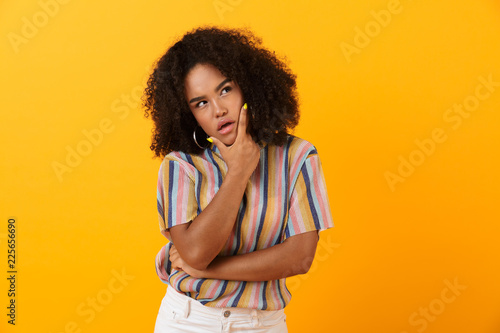 фотографія Thoughtful young african cute girl posing isolated over yellow background