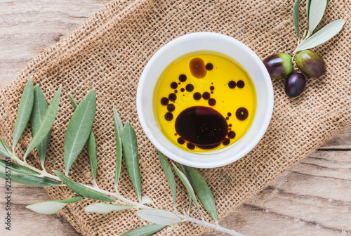 Olive oil and vinegar on wooden background.