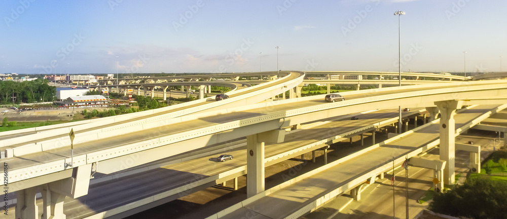 Panorama horizontal aerial view massive highway intersection, stack interchange blue sky in Houston, Texas, USA. Elevated road junction overpass, five-level freeway carry heavy rush hour traffic