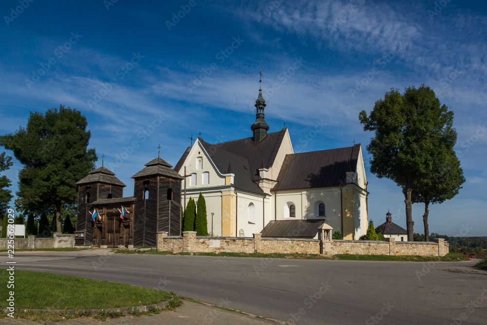 Fototapeta premium Church and larch gate in Krynki, Swietokrzyskie, Poland