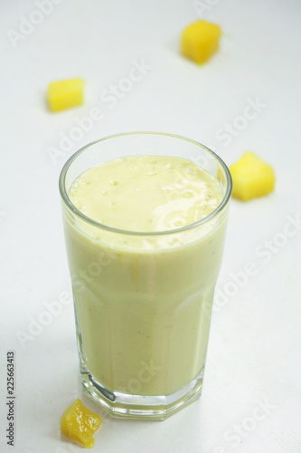 Healthy mango smoothie in a glass on a white background