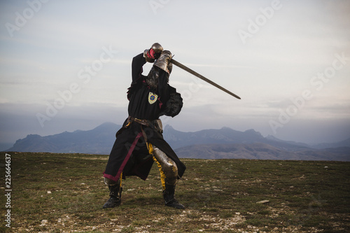 Fotografie the knight in armor beats the sword