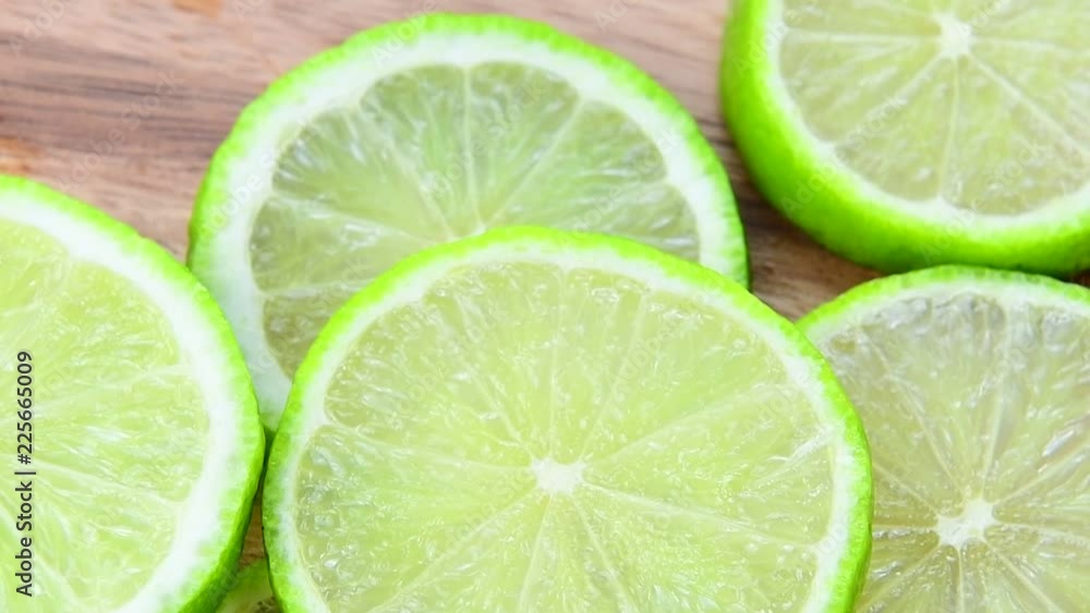 Fresh green lime slice is slowly rotating in the studio Fresh green lime slice is slowly rotating in the studio