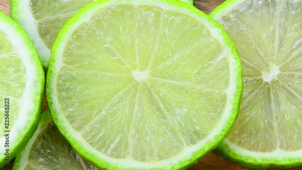 Fresh green lime slice is slowly rotating in the studio Fresh green lime slice is slowly rotating in the studio